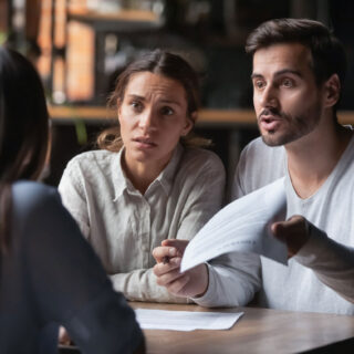 Frustrated couple reviewing legal paperwork after lawyer dropped their car accident case in Texas